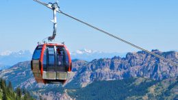 Red gondola car carrying people up the mountain in summer at Crystal Mountain