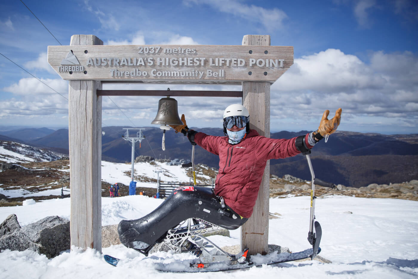 Adaptive skier at the top of Thredbo about to ring a bell.