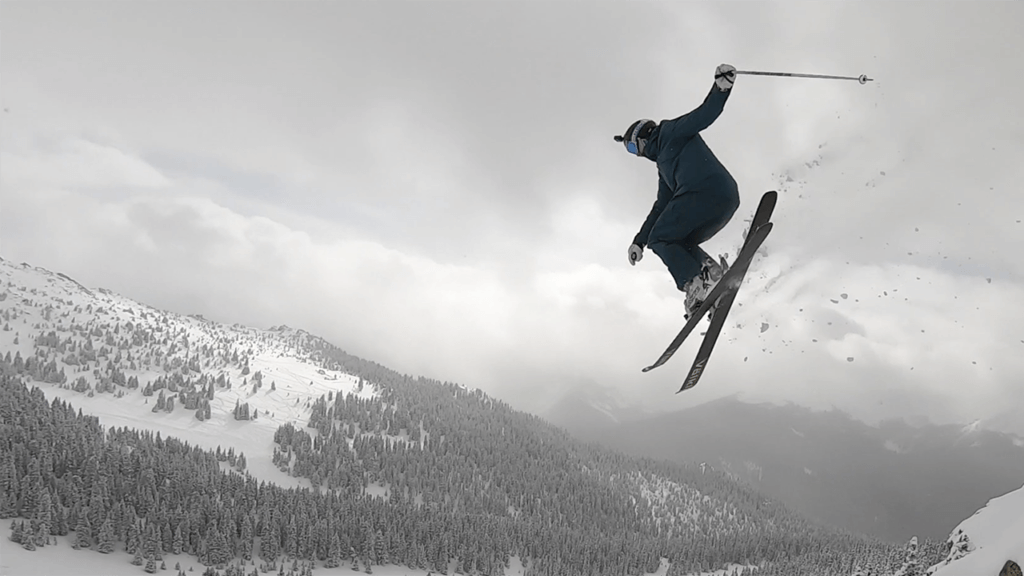 A skier catching some air off a jump on a snowy day. One of Our favorite things about the mountains