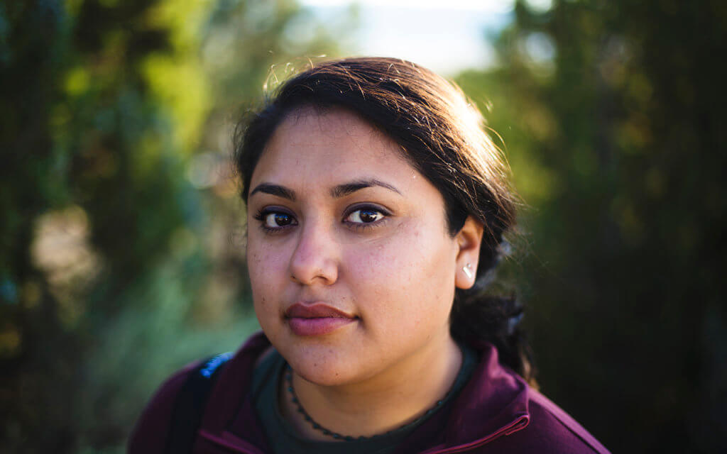 Close up image of a BIPOC woman with a blurred background.