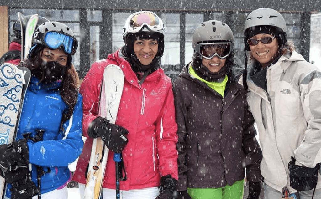Women of color in ski gear on a snowy day, part of Ikon Pass and SheJumps initiative to get more women on the mountain
