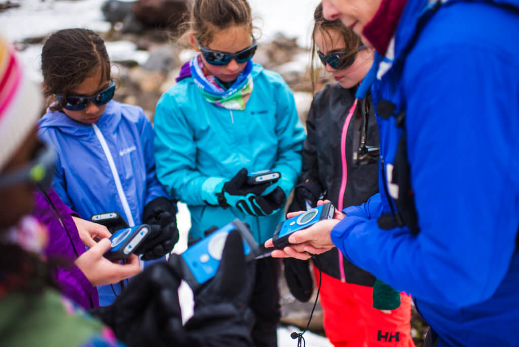 Girls learning to use GPS trackers in a Wild Skills course for on-mountain survival