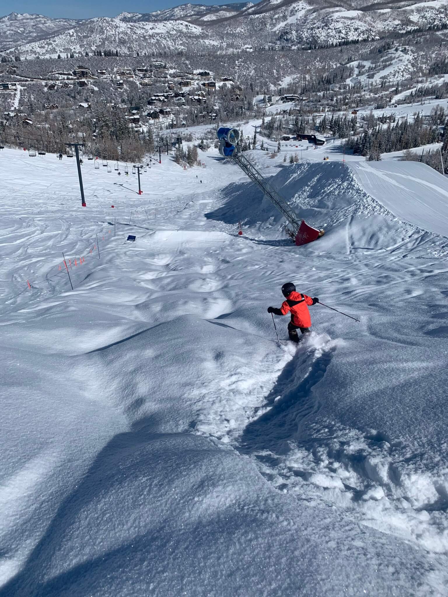 young kid skiing through powder covered moguls