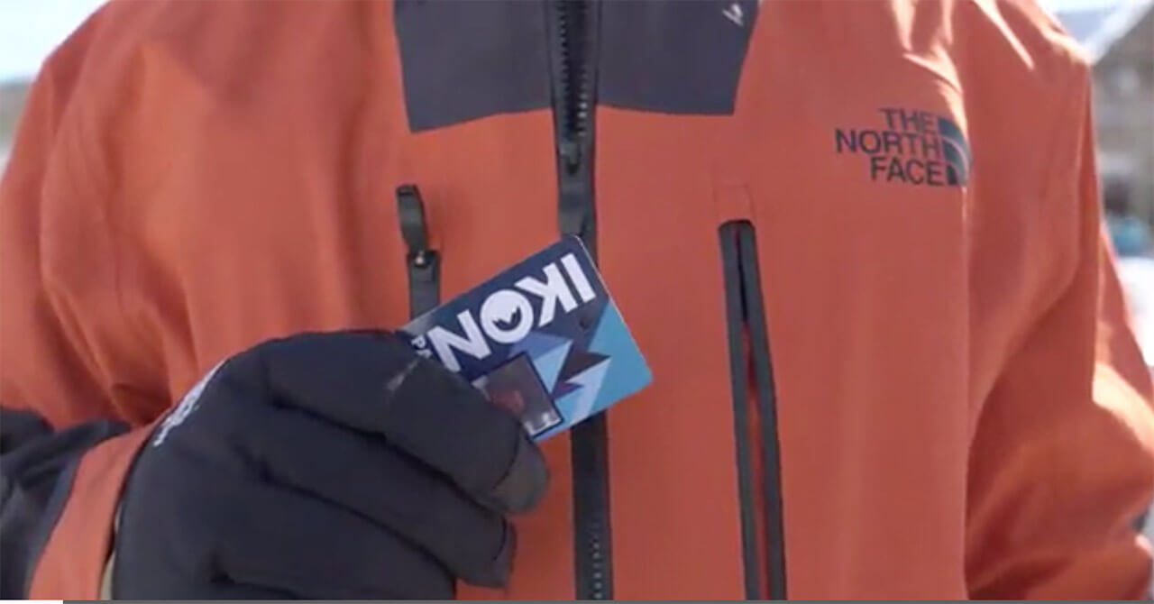 Skier holding Ikon Pass media