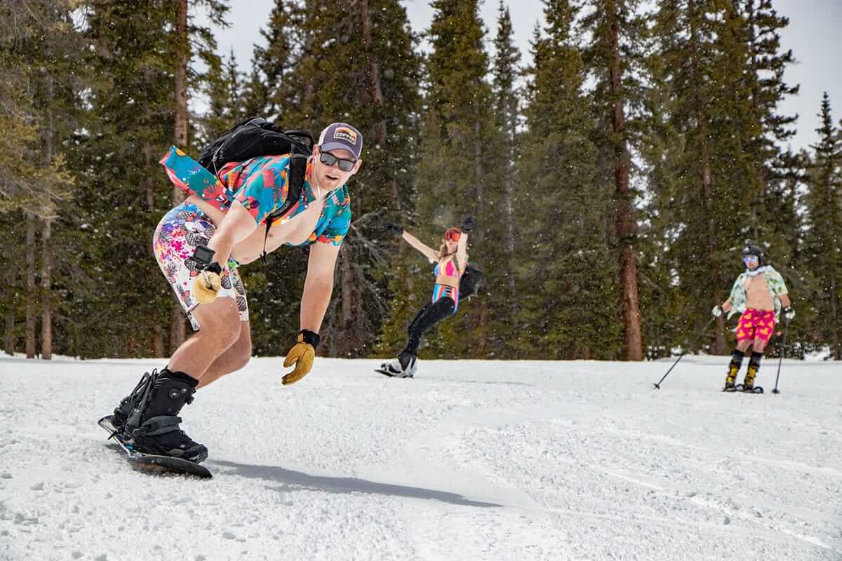 Snowboarder and skiers enjoying spring on the mountain