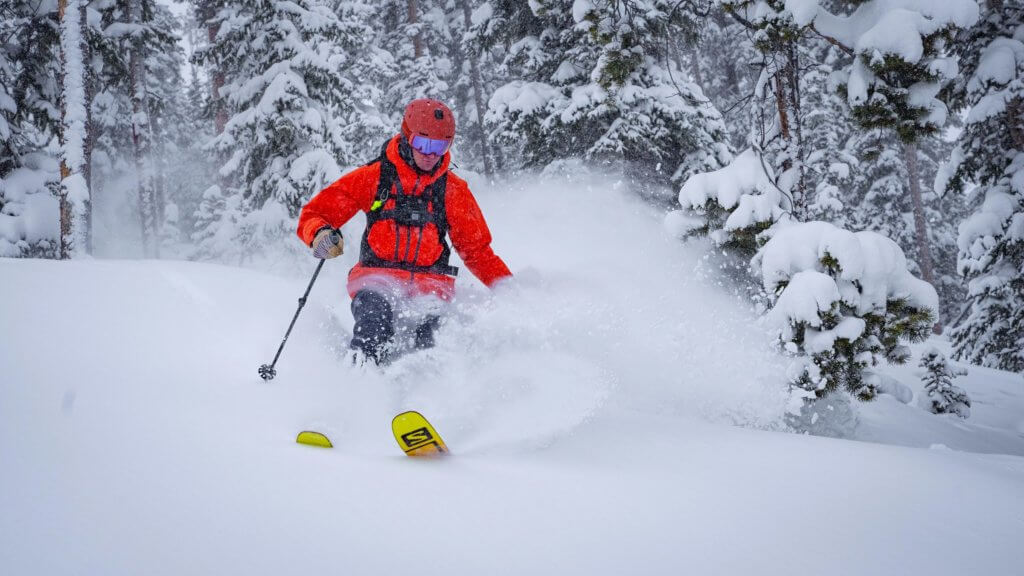 Skier going through deep powder on a snowy day