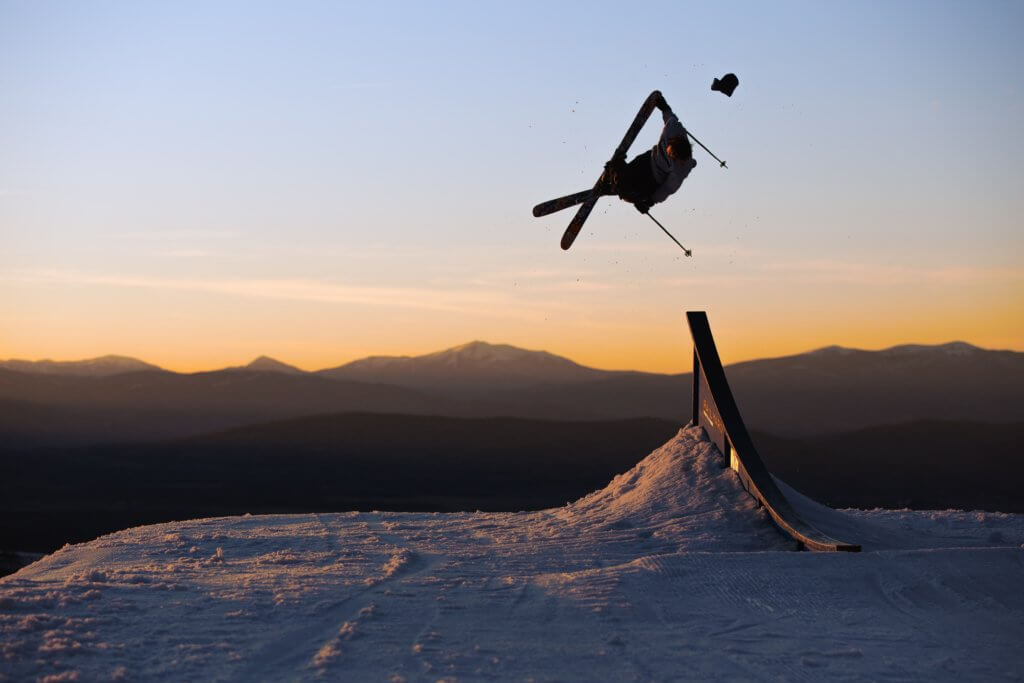 Winter athlete Birk Irving performing an aerial trick at sunset at Winter Park resort in Colorado.