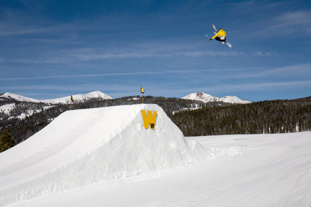 Skier performing a trick off a jump at Woodward Park at Copper Mountain