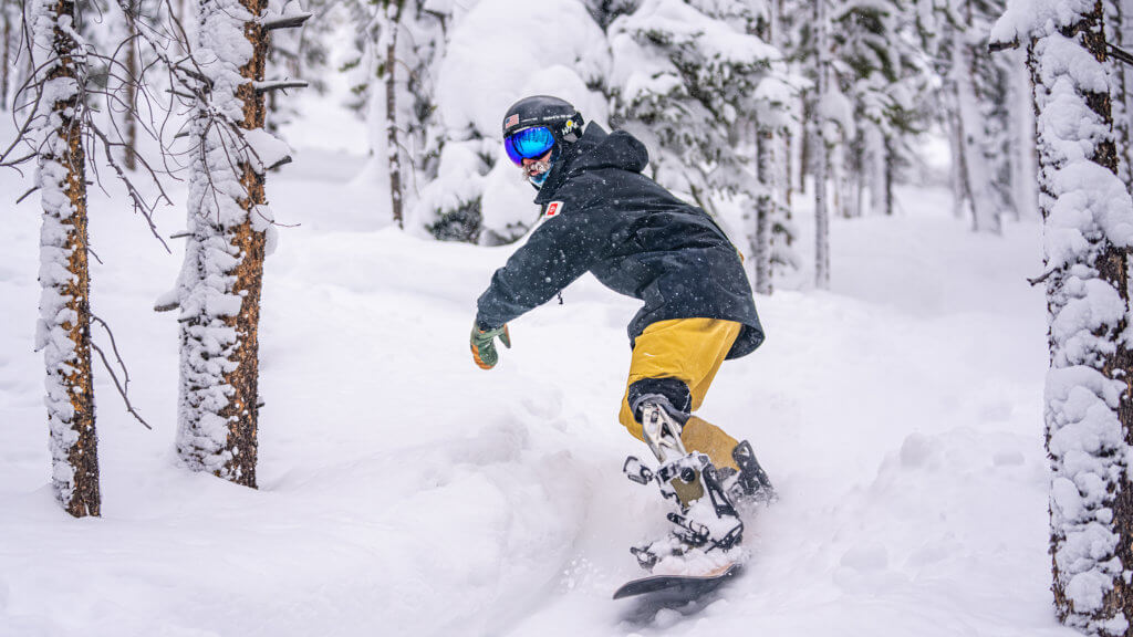 Adaptive skier riding through powder and trees at Winter Park Resort