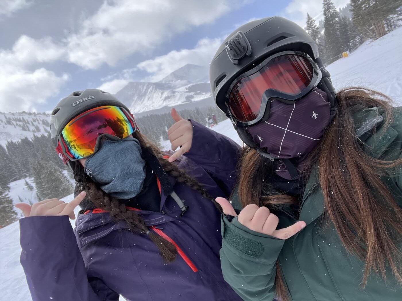 SheJumps scholarship recipient Jessica Beltran dressed in ski gear, taking a photo with her friend, also dressed in ski gear