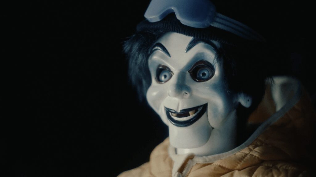 Creepy puppet wearing winter jacket and goggles