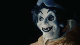 Creepy puppet wearing winter jacket and goggles