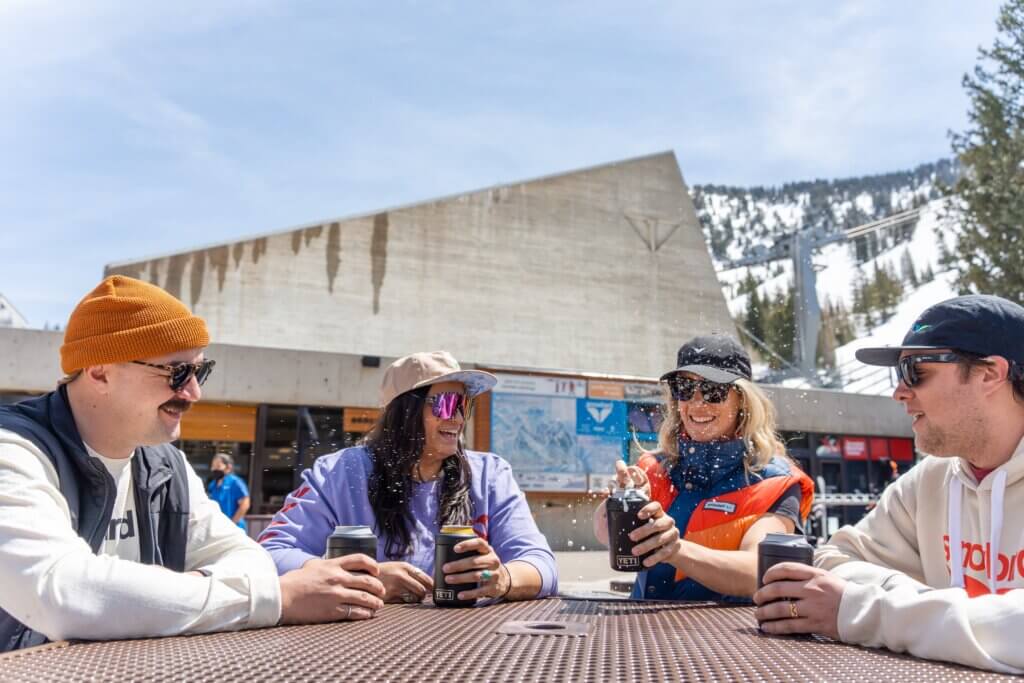 Group of people sitting at a table at the base of a ski resort