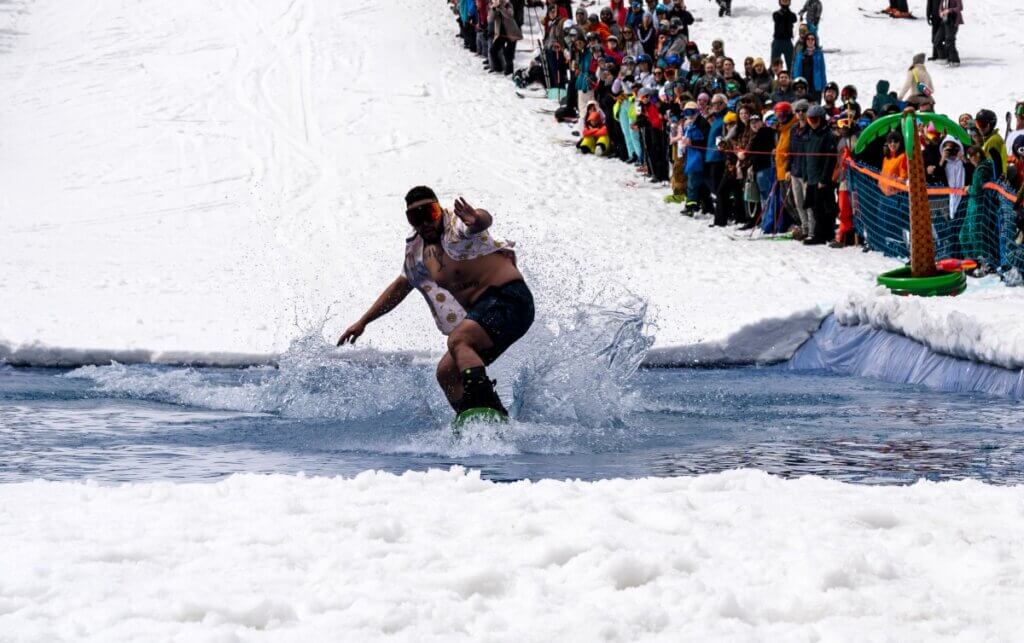 Snowboarder skims across a pond.