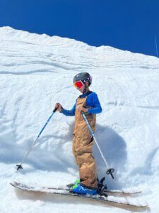 Person in ski gear standing in front of a pile of snow