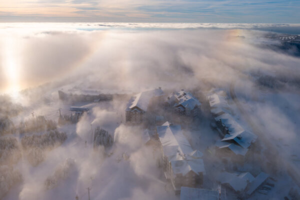 Cloud coverage at dawn over a snowy mountain resort.