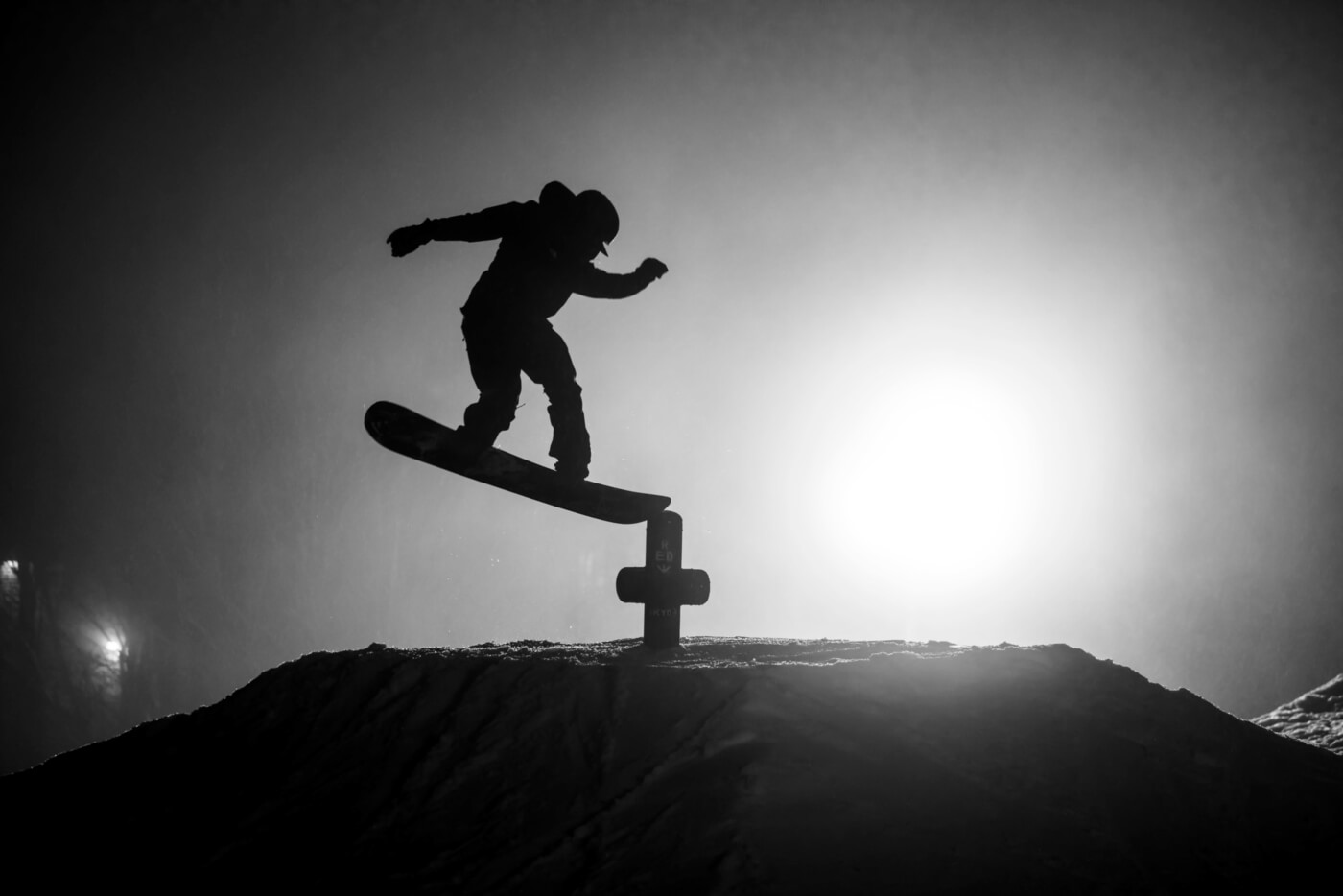 Black and white imaged of a snowboarder silhouetted mid-air.