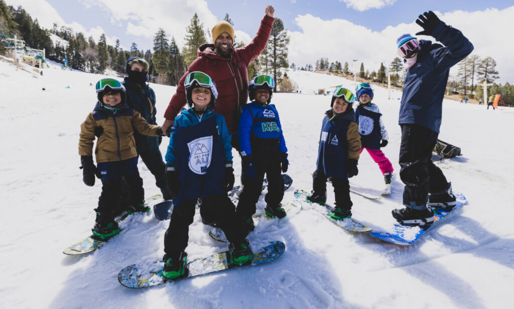 Group of kids out snowboarding with two adults.