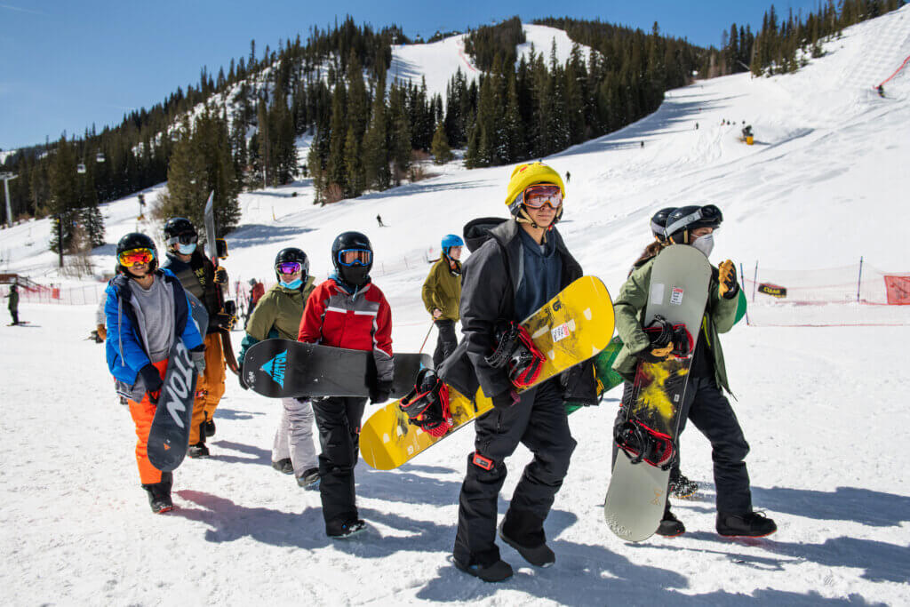 Group of kids heads out for a day of snowboarding.