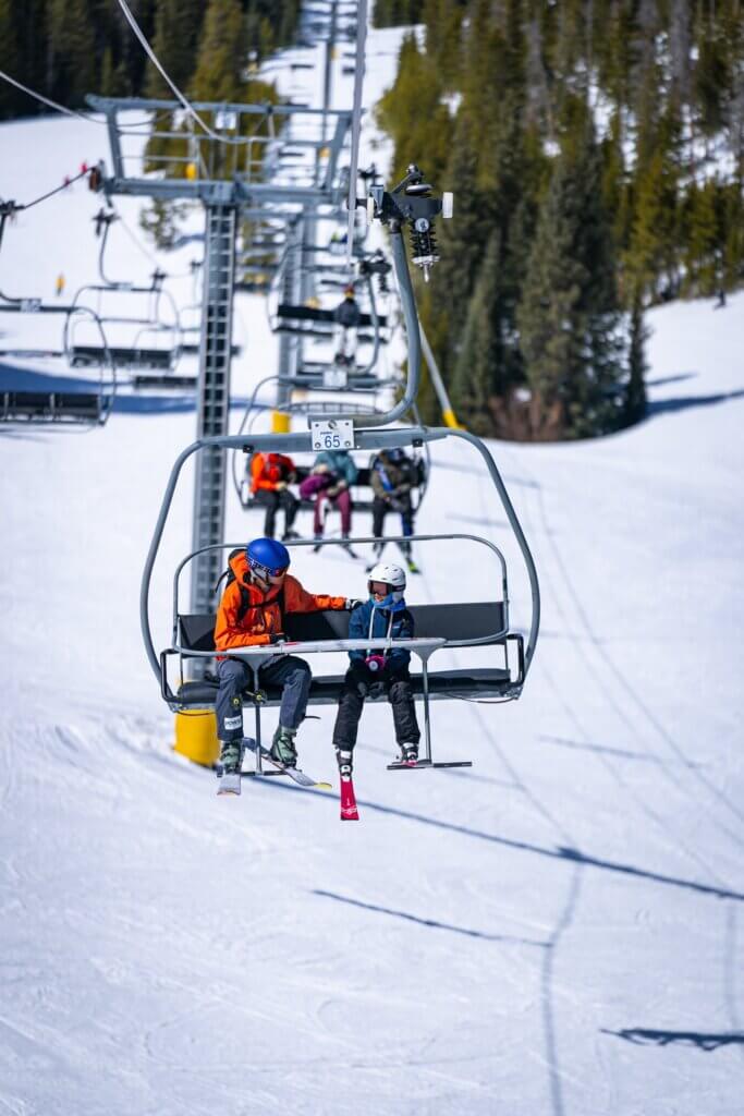Connor and a scholarship recipient riding a ski lift.