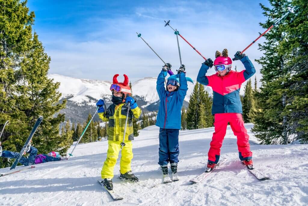 Group of kids celebrating on skis.