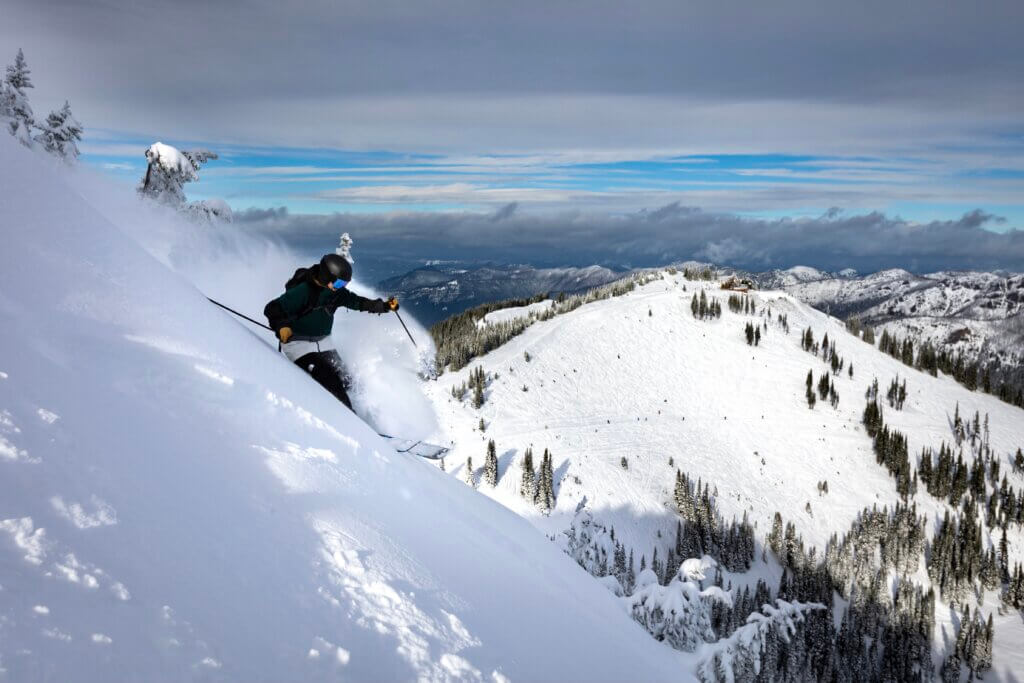 Skier riding down a steep hill.