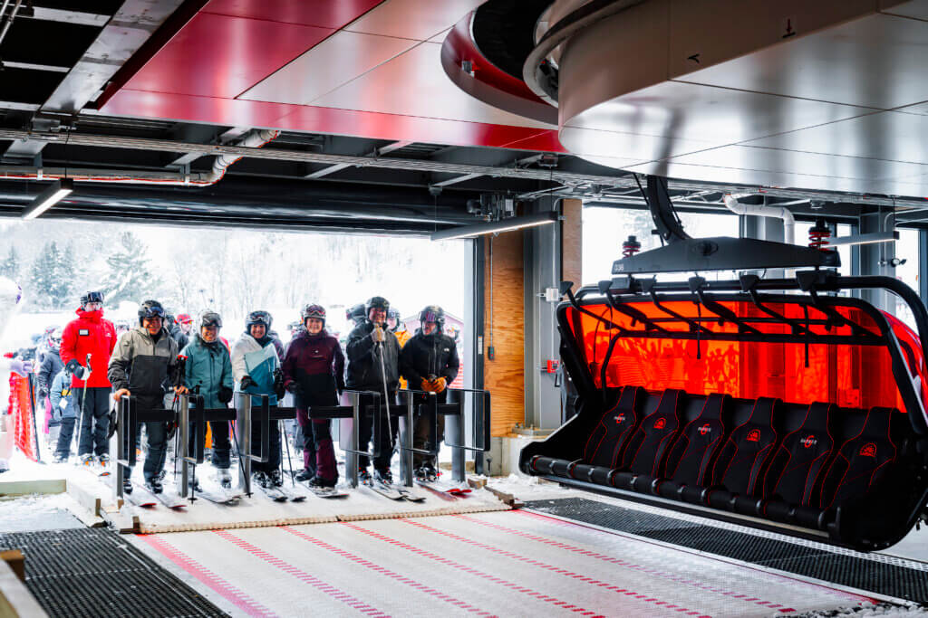 Group of people waiting to board a chairlift.