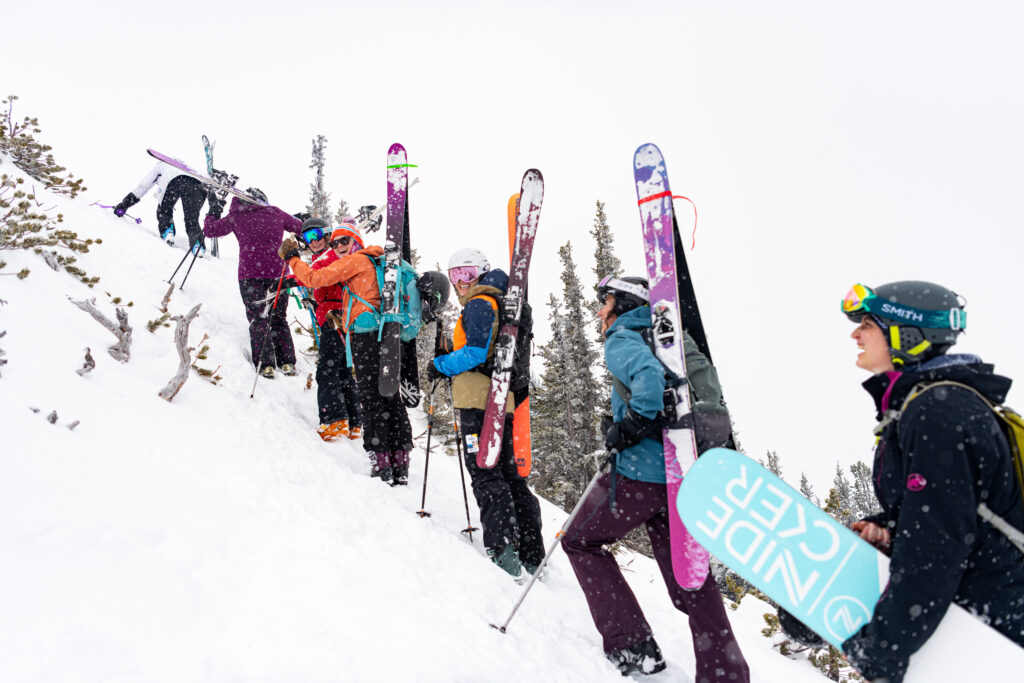 women skiers hiking up a mountain