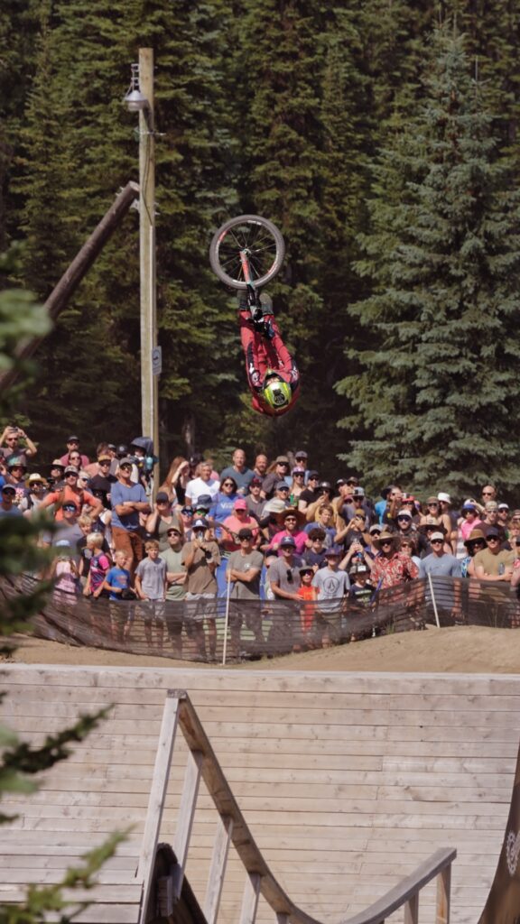 Mountain biker doing an aerial trick in front of a large crowd