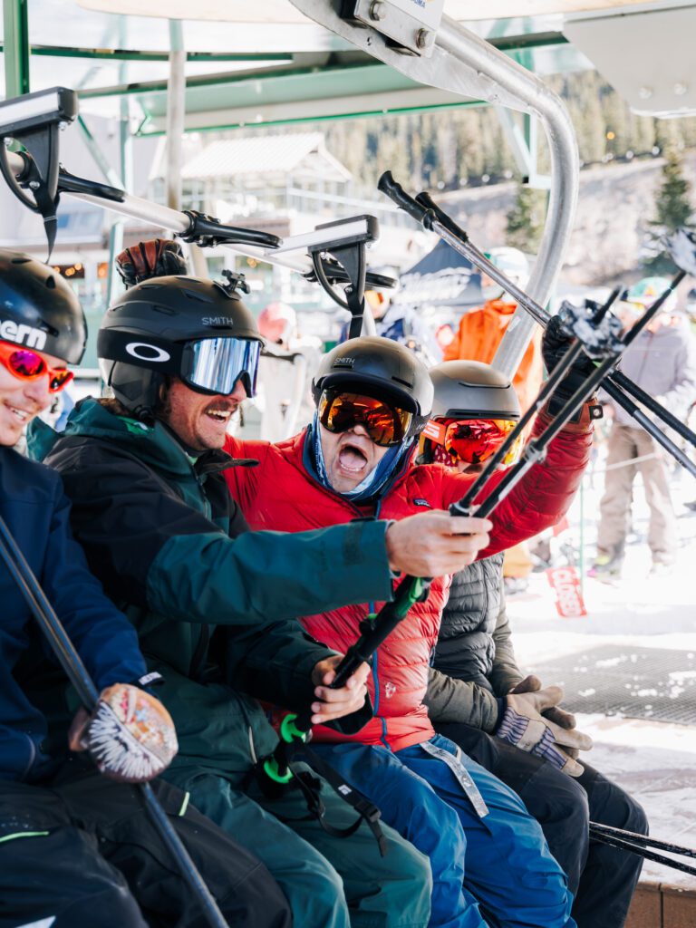 Group cheering on chairlift at Arapahoe Basin opening day 2026-2027 season