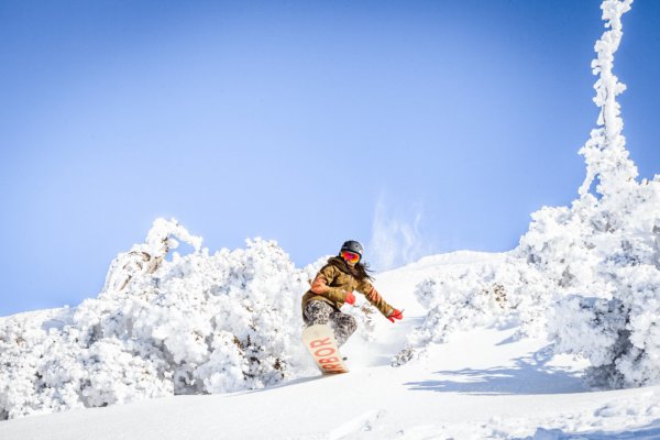 Female snowboarder going through powder at Big Bear Resort