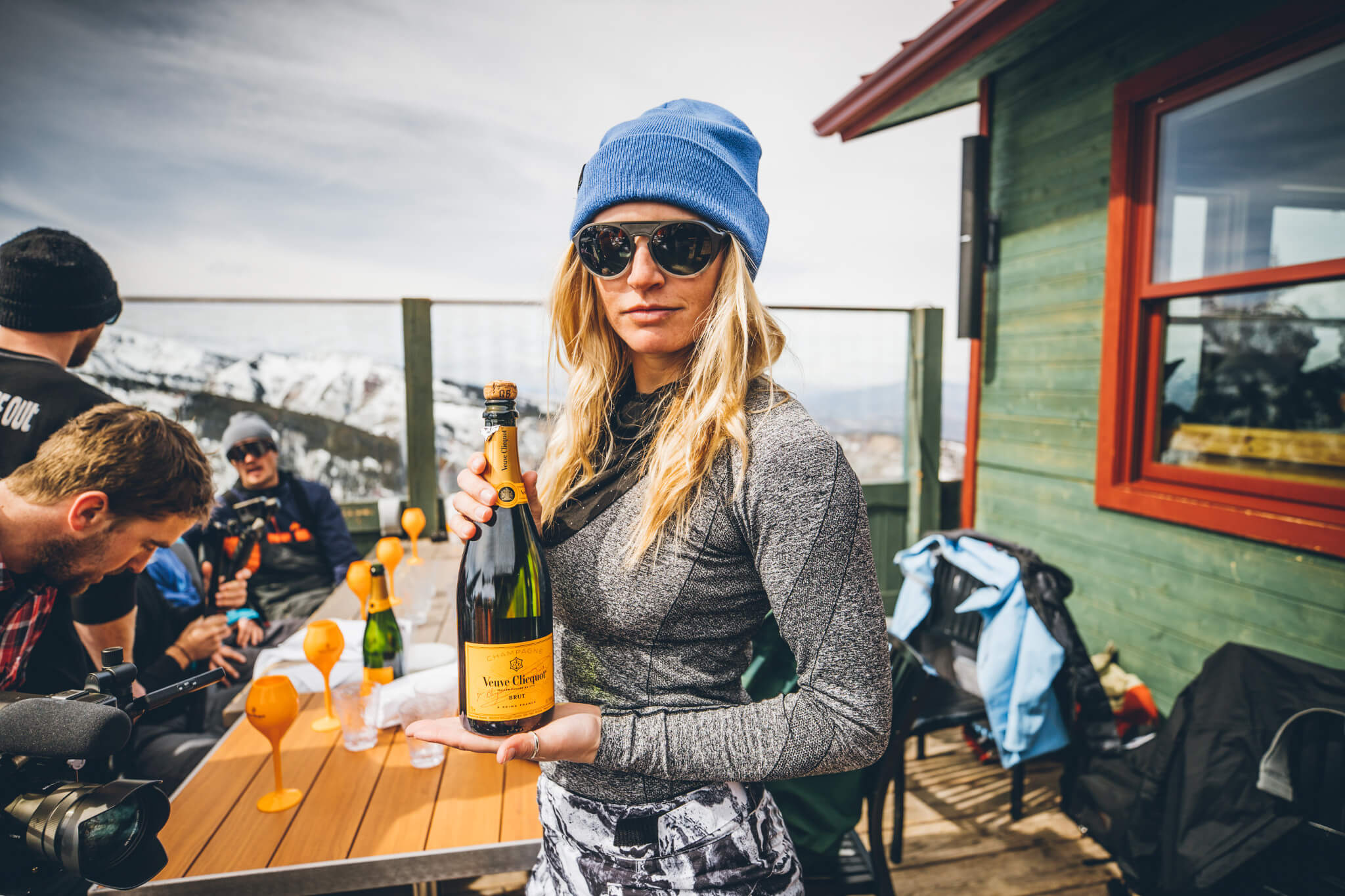 Female ski athlete holding a bottle of champagne at Cloud Nine at Aspen Highlands