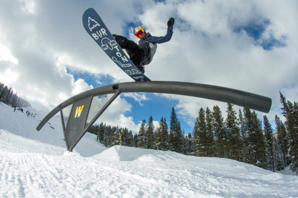 Snowboarder sliding on a rail at Woodward terrain park at Copper Mountain