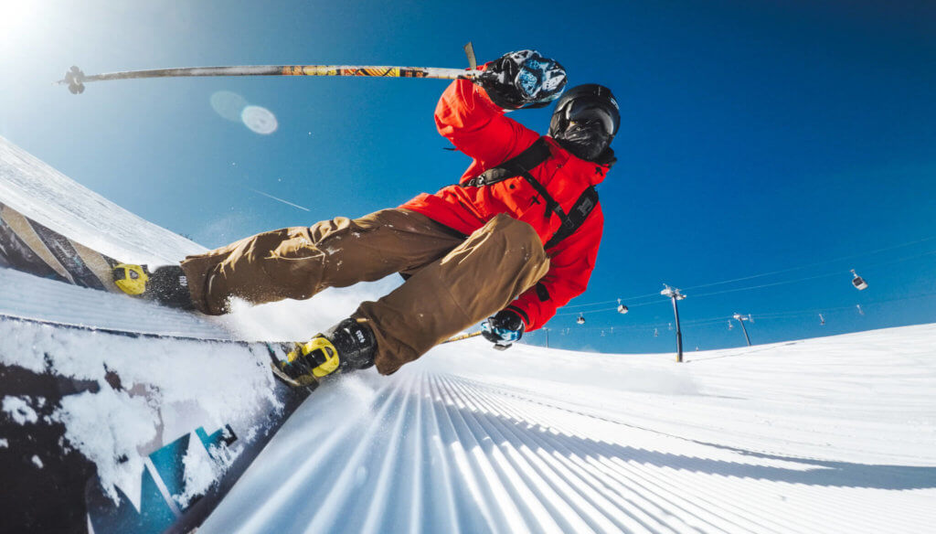 Low angle shot of a skier gliding across a freshly groomed ski run