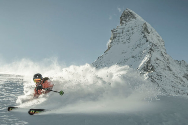 Skier carving fresh powder at Zermatt with the Matterhorn peak in the background