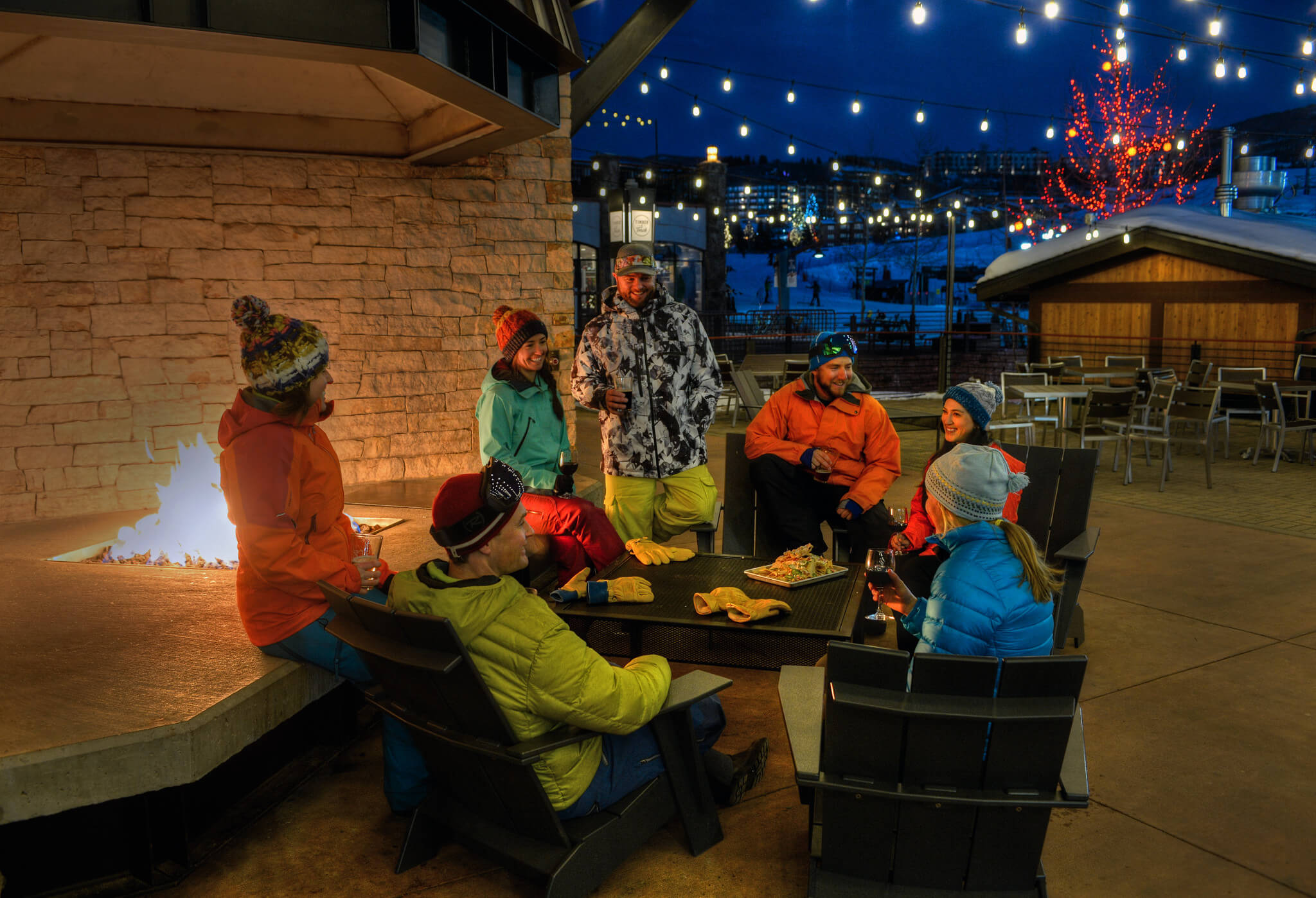 Group of friends enjoying après drinks in the evening on the patio at Timber & Torch at Steamboat