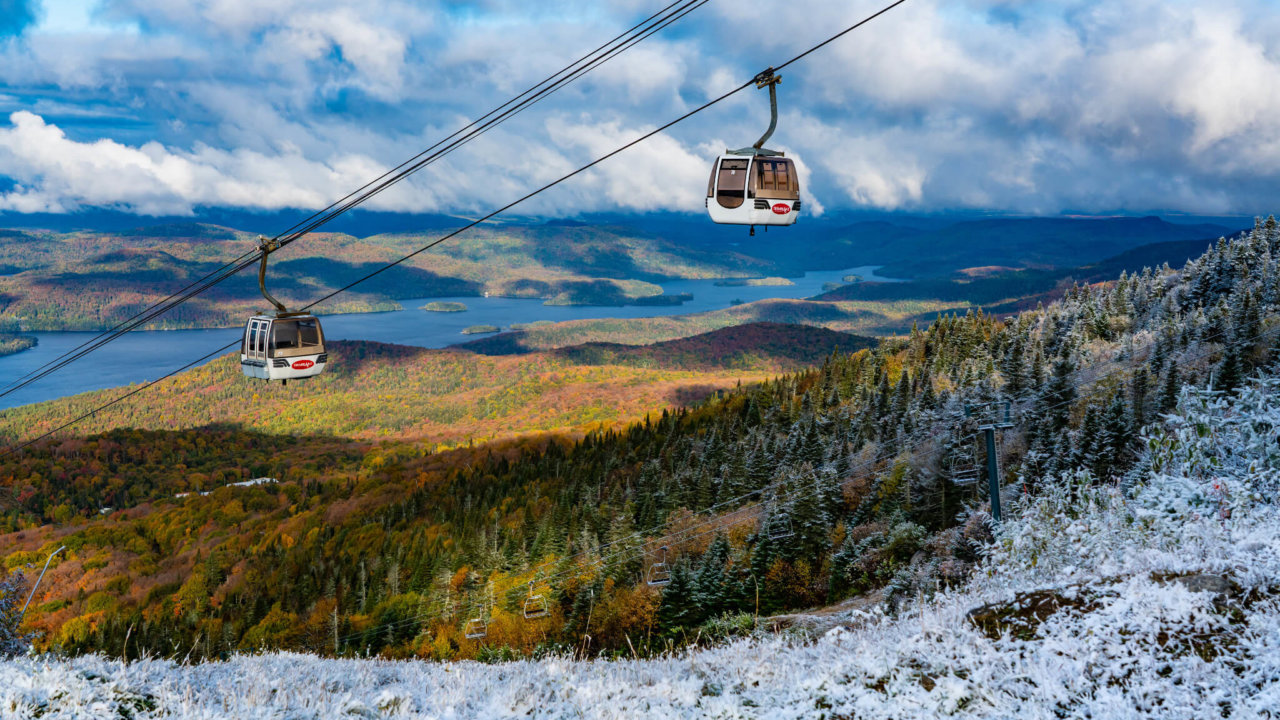 Tremblant gondola with fall colors in the background and some sprinkles of snow in the foreground