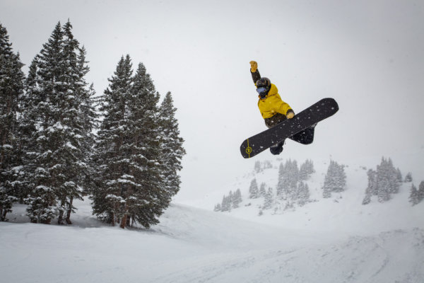 Snowboarder performing a jump on a snowy day