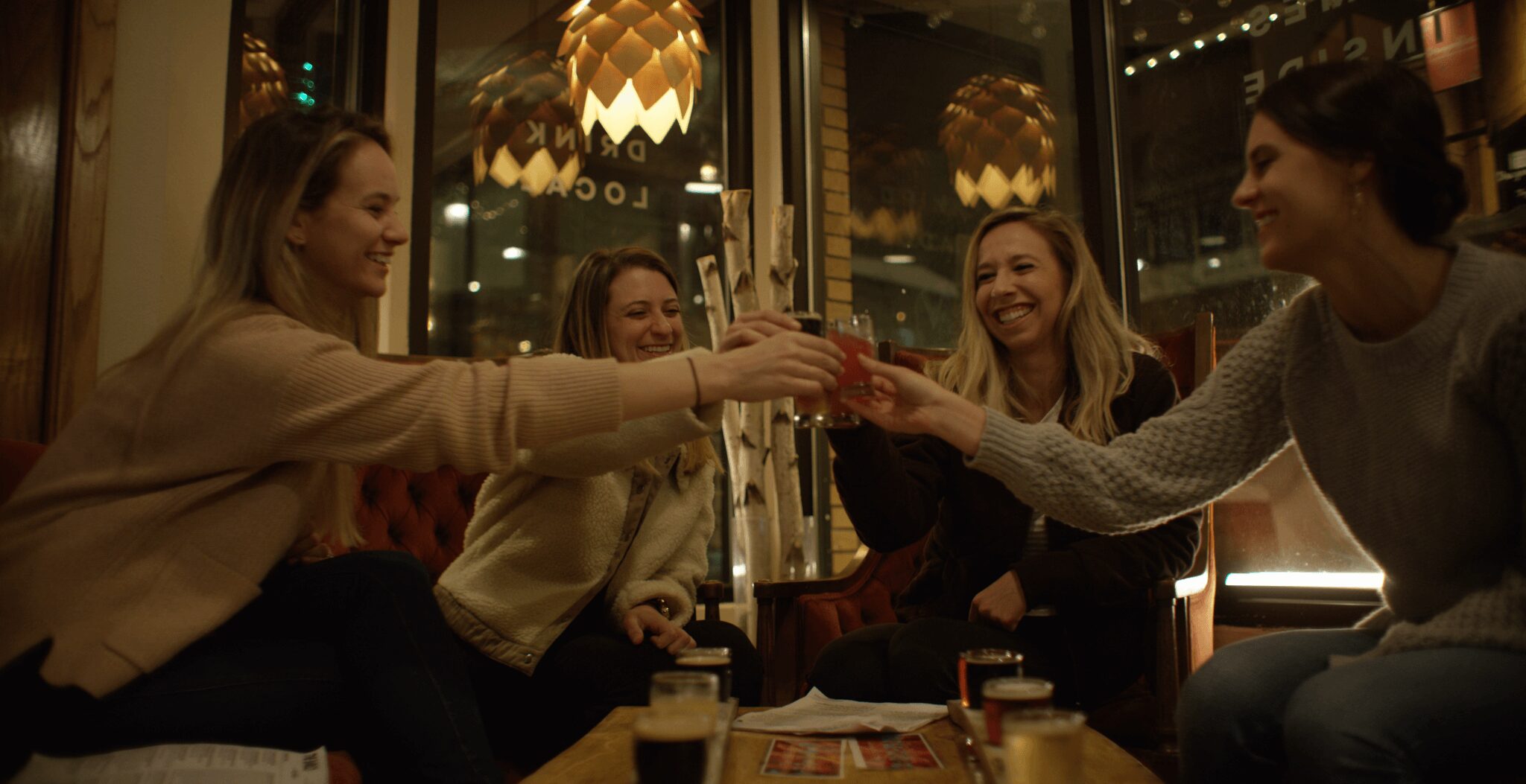 Girlfriends toasting glasses of beer at a bar in Steamboat, Colorado