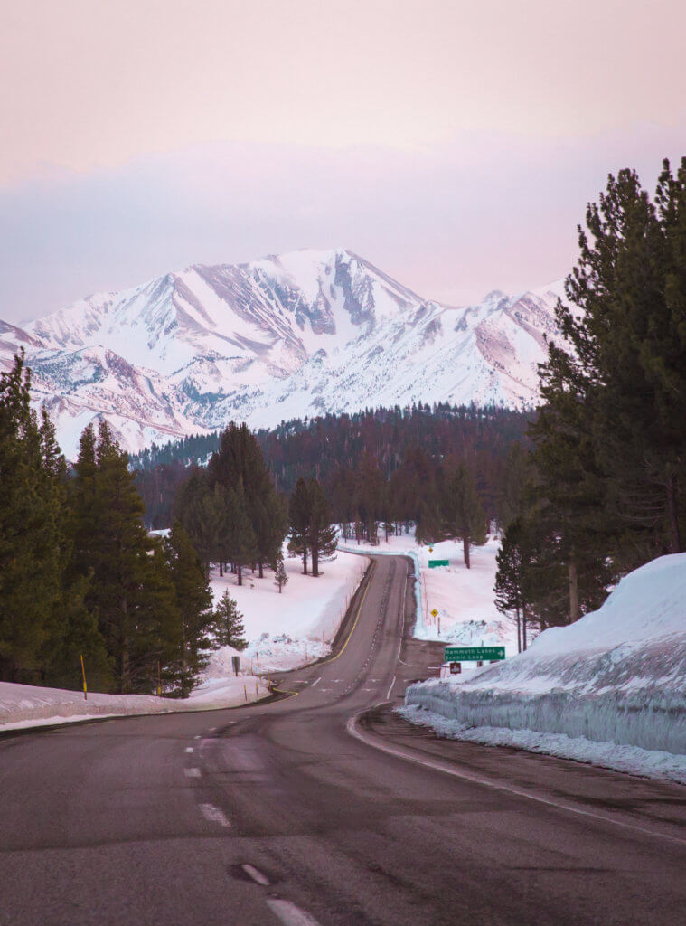 Empty road leading to snow covered mountains in California near June Mountain