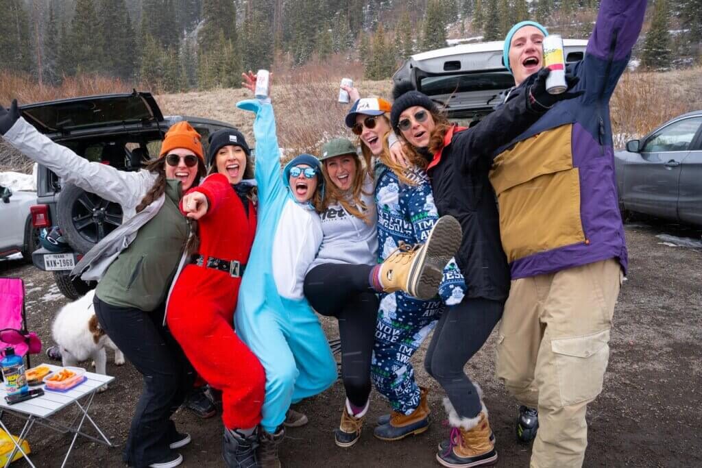 Group of people in fun outfits at one of the best mountain beach scenes, The Beach at Arapahoe Basin